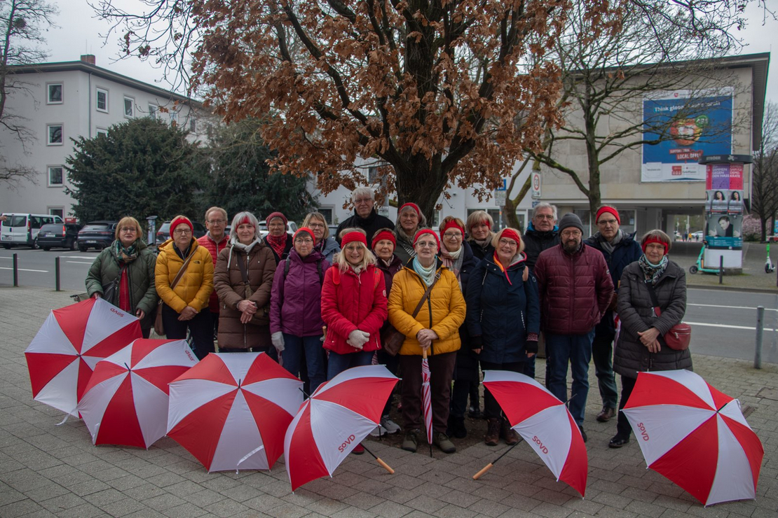 Die Teilnehmer aus dem Kreis Diepholz posieren mit rot-weißen Regenschirmen.