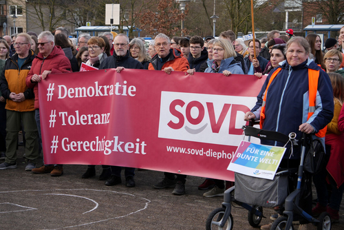 SoVD-Mitglieder zeigen ein Banner mit unseren Werten.